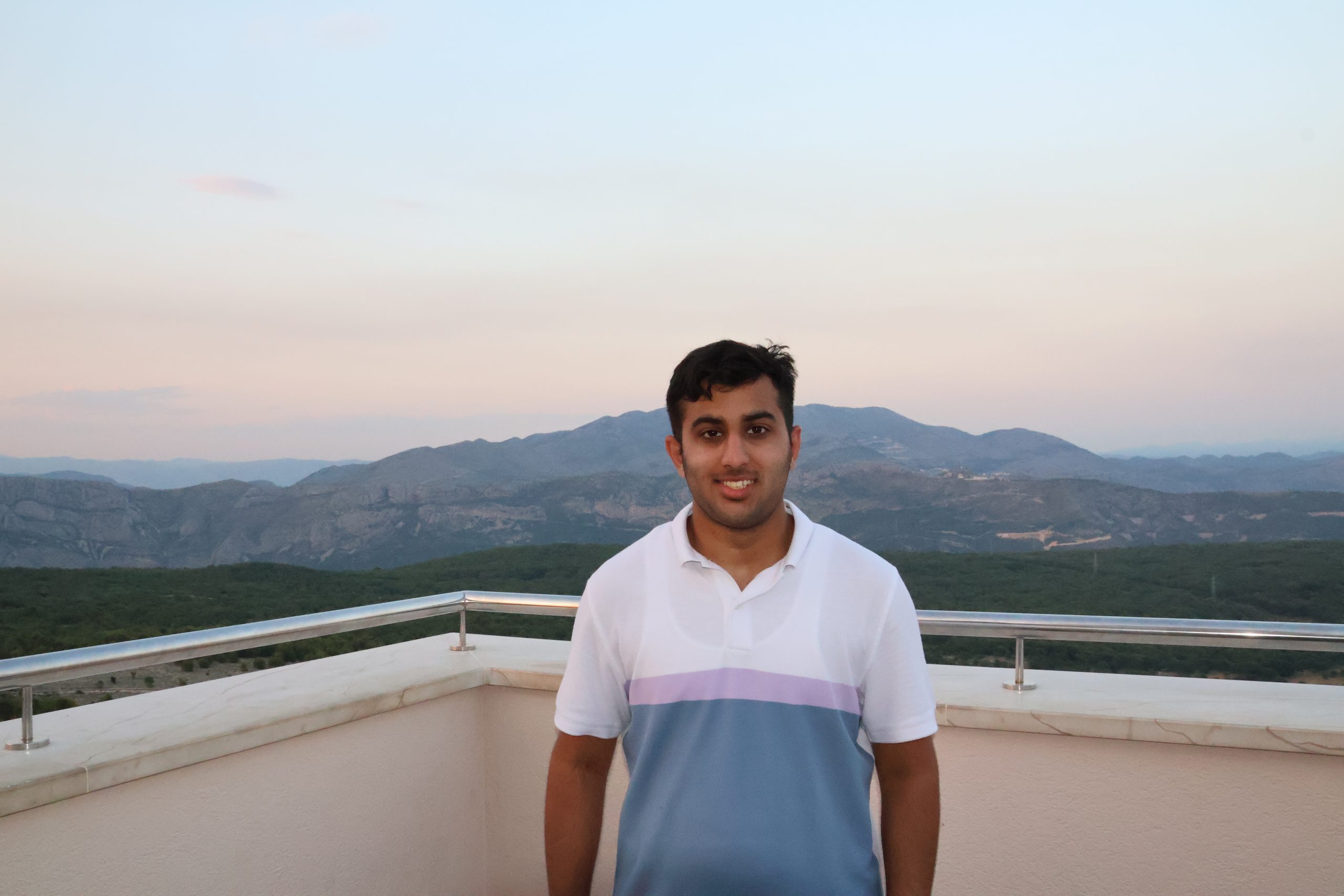 Umer standing above Dubrovnik with mountains in the background.